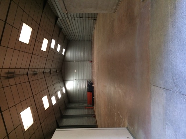 Intérieur hall industriel, vue vers portes de quai