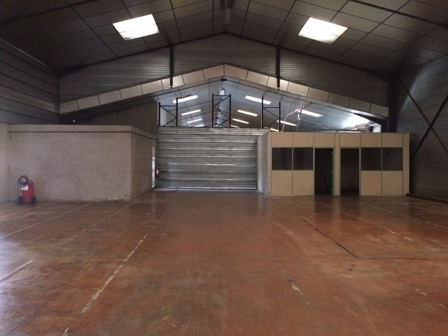 Intérieur hall avec mezzanine de stockage et bureau vitré